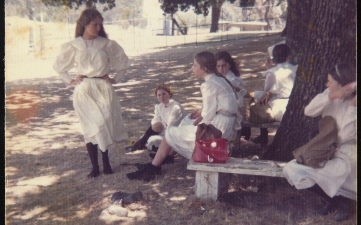 group of young women sat around tree in Picnic at Hanging Rock costumes